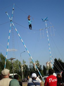 Oldest (Apparently, In Central Asia) Tightrope Walker. Small Girl Balancing On His Shoulders.