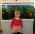 Anna In Baba's Homemade Dress In Front Of Fish